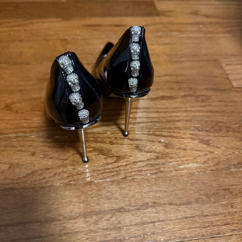 Patent leather black heels with a silver heel.